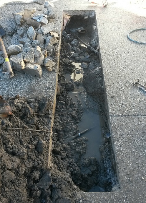 Concealed leak being repaired under concrete driveway